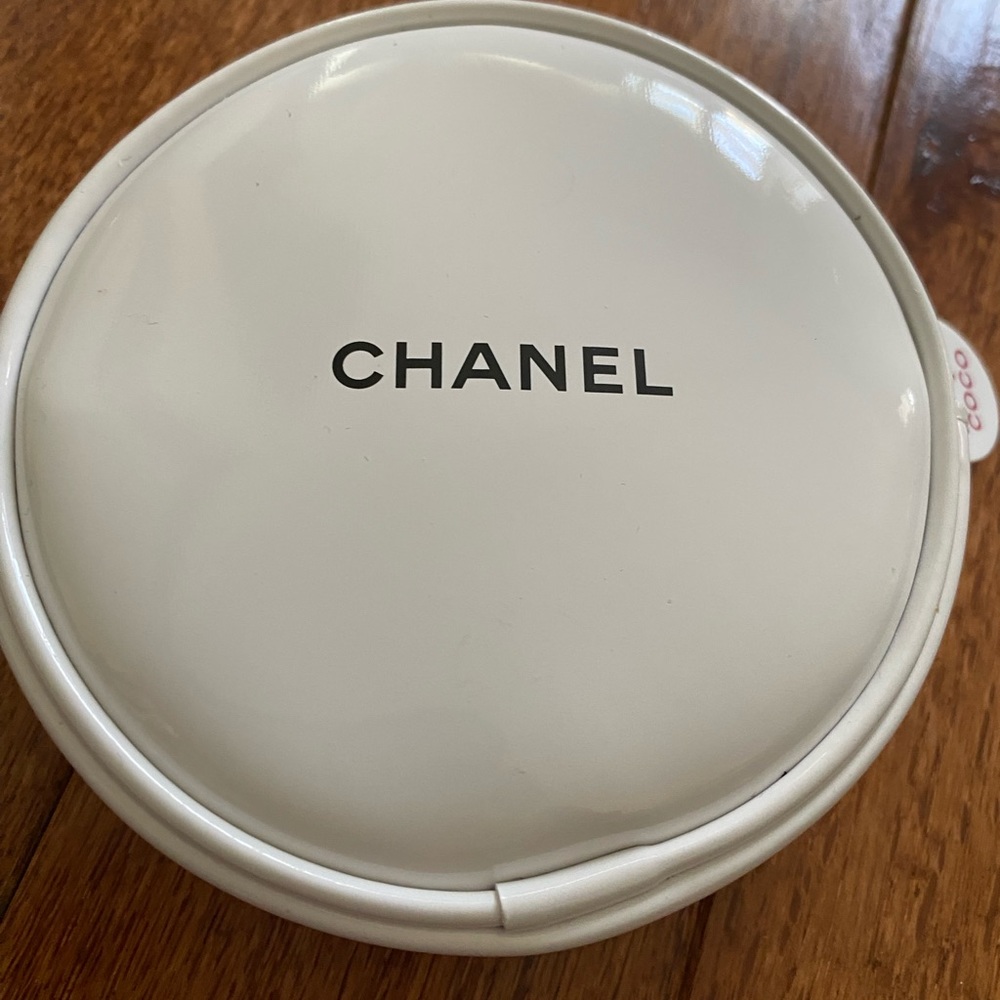 A round white Chanel make up bag